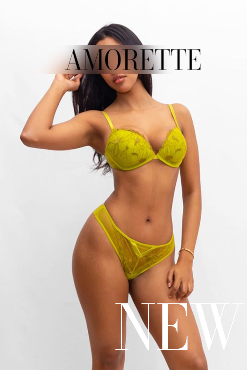 amorette international brown-skinned girl with black hair in yellow dessous pulling and playing with her hair
