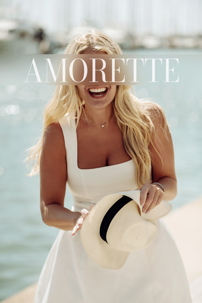 elite escort model olivia brussels shows her beautiful and happy smile, her white teeths, wearing a white dress, her long blonde hair is open and wavy