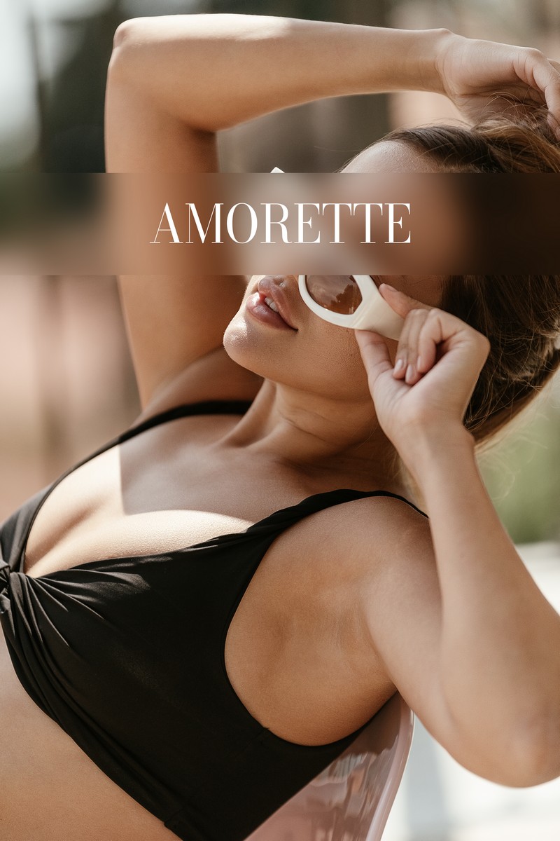 Alina – Elite Escort Model from Frankfurt alina elite escort model from frankfurt showing her from the side while sitting on a chair in black bikini, she shows her perfect toned skin and sporty body, her long brown hair is bonded, white sunglases, natrural escort, high class escort, international, luxury, vacation, summer